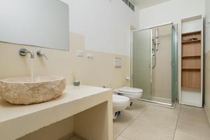 a bathroom with a sink and a toilet and a shower at Cormorani appartamento N 5 in Golfo Aranci +22 photos