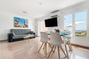a living room with a couch and a table with chairs at Santa Ana 23 in Playa del Ingles