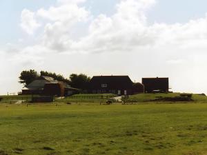 a large field with a barn and a house at Fewo Nordseeblick in Langeneß +28 photos