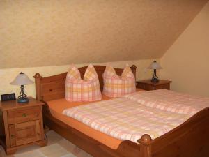 a bedroom with a bed with pillows and two lamps at Fewo Nordseeblick in Langeneß