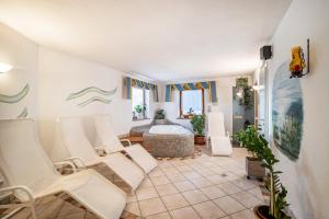 a living room with white chairs and a bath tub at App Hubertus - Moosstock in Sand in Taufers
