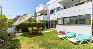 a backyard with lawn chairs and an umbrella at Francisca in Pollença