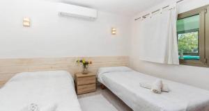 two beds in a room with a window at Francisca in Pollença +15 photos