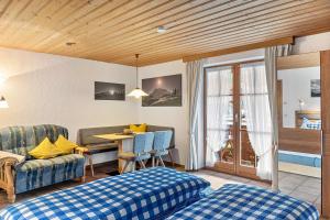 a room with a bed and a table and a couch at Haus Verena Mittenwald in Mittenwald