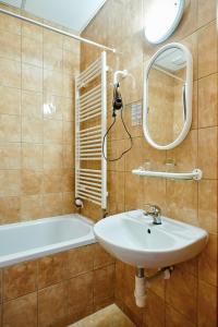 a bathroom with a sink and a tub and a mirror at Hotel Terasa in Vimperk