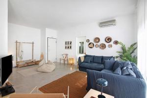 a living room with a blue couch in a room at Balaia 9 in Olhos de Água