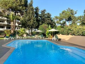 a swimming pool in a resort with chairs and umbrellas at Balaia 9 in Olhos de Água