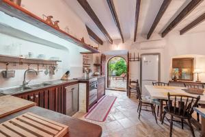 an open kitchen and dining room with a table and chairs at Se Teulere in Fornalutx