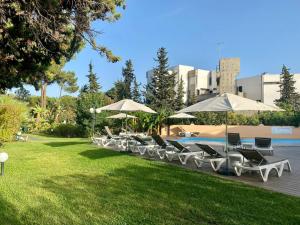 a row of lounge chairs and umbrellas next to a pool at Balaia 9 in Olhos de Água