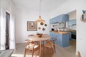 a kitchen with blue cabinets and a table and chairs at Balaia 9 in Olhos de Água