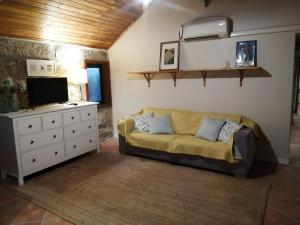 a living room with a couch and a tv at Casa de Andrães - Glicíneas in Marco de Canaveses