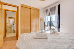 a bedroom with a white bed with towels on it at Villa Norteventura in Majanicho +37 photos