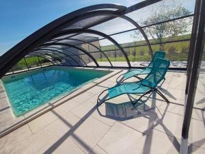 a blue chair sitting next to a swimming pool at Gîte les 2 Fontaines in Marans