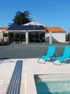 two blue chairs sitting next to a swimming pool at Gîte les 2 Fontaines in Marans