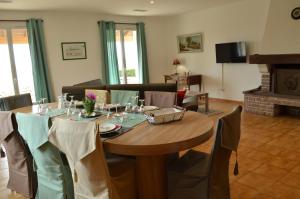a dining room with a table with chairs and a fireplace at Gîte les 2 Fontaines in Marans