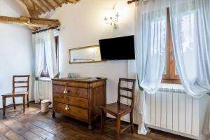 a room with a dresser and two chairs and a television at Tenuta Ca' Zen - Cottage Casetta in Taglio di Po