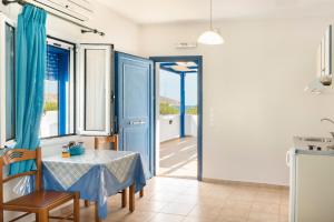 a dining room with a table and a blue door at Studios Ninemia Serifos 5 in Livadi +12 photos
