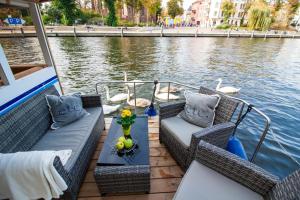 ein Boot mit Korbstühlen und einem Tisch auf dem Wasser in der Unterkunft Lisa Boot 4 in Priepert