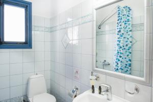 a bathroom with a toilet and a sink and a mirror at Studios Ninemia Serifos 5 in Livadi