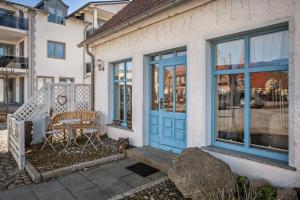 a house with a blue door and a table at Ferienzimmer auf Der Insel Rügen in Sagard