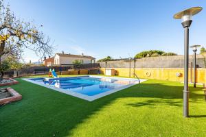 a swimming pool in a yard with a green lawn at Masia Can Divi in La Ametlla