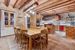 a large kitchen with a wooden table and chairs at Masia Can Divi in La Ametlla