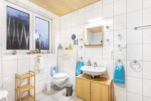 a bathroom with a sink and a toilet and a mirror at Ferienhaus Hohlwegstübchen in Sundern +29 photos