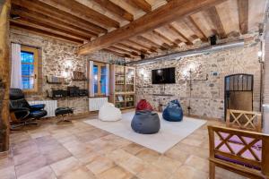 a living room with stone walls and a tv at Masia Can Divi in La Ametlla