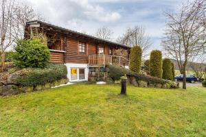 a log house with a yard in front of it at Ferienhaus Hohlwegstübchen in Sundern