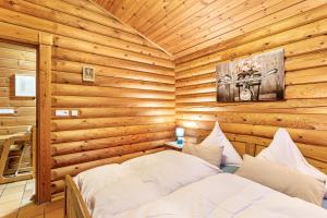 a bedroom with a bed in a wooden cabin at Ferienhaus Hohlwegstübchen in Sundern