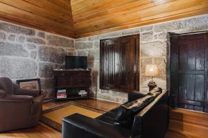a living room with a stone wall at Cantinho da Tilde in Fafe