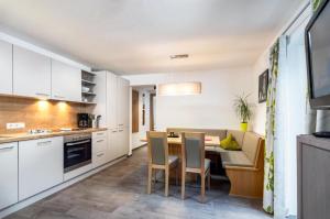 a kitchen and dining room with a table and chairs at Haus Sabrina Rotpleiskopf in See