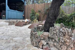 a stone patio with a tree and a bench at casa Sa Breca in Tertenìa
