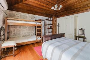 a bedroom with two bunk beds and a wooden ceiling at Cantinho da Tilde in Fafe