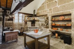 an old stone kitchen with a table and a stove at Cantinho da Tilde in Fafe +28 photos