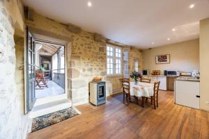 a kitchen and dining room with a table and a stove at Appartement Andraut - Bazas in Bazas