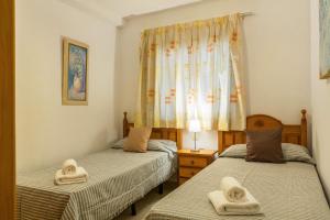 two twin beds in a room with towels on them at Su Eminencia in Mogán +22 photos