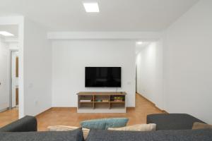 a living room with a tv and a couch at S Q Playa de Sardina in Gáldar
