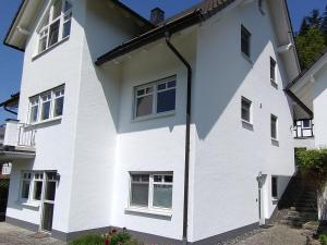 a white house with a lot of windows at Ferienwohnung Am Kamp in Schmallenberg