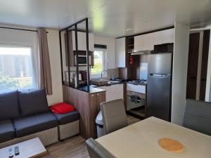 a kitchen and living room with a couch and a table at Mobilehome familial in Gastes