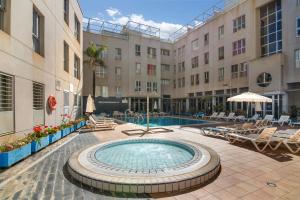a courtyard with a swimming pool in a building at S Q Playa de Sardina in Gáldar