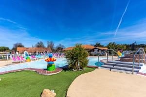 a water park with a large pool with a playground at Mobilehome familial in Gastes