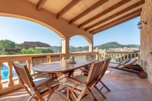 a patio with a wooden table and chairs on a deck at Solluna in Son Servera