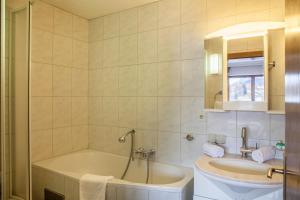 a bathroom with a tub and a sink at Haus Excelsior Top 21 in Seefeld in Tirol +32 photos