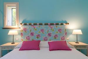 a bedroom with a large bed with pink pillows at Casetta Maya in Riparbella +19 photos