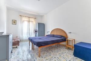a bedroom with a bed with a blue blanket at Casa La Torre in Capoliveri