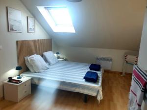 a bedroom with a bed with blue sheets and a skylight at Le Refuge Salin in Batz-sur-Mer +17 photos