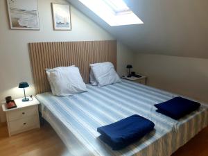 a bedroom with a large bed with two blue pillows at Le Refuge Salin in Batz-sur-Mer