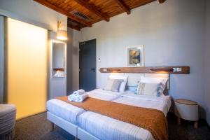 a bedroom with a large bed in a room at PHOENIX maison d'hôtes & SPA in Ginasservis