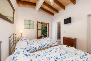 a bedroom with two beds and a tv at Finca Es Carregador in Capdepera +22 photos
